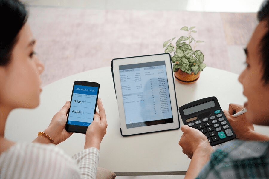 Two people calculating their sales with a calculator | Condor PH