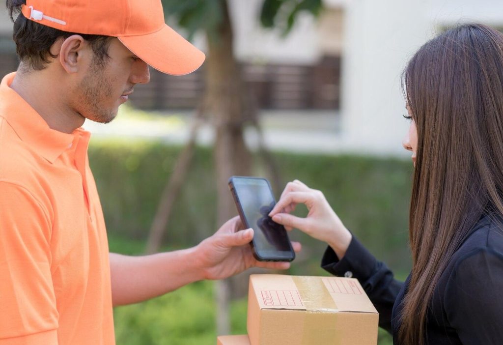 Woman Customer Signs Electronic Signature Mobile Device While Receiving Package | Condor PH