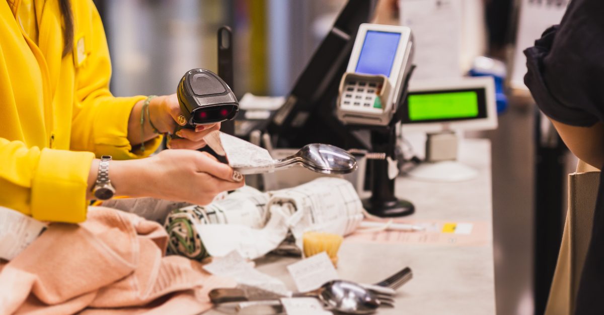 A cashier holding a barcode scanner punching the pricetag of product at the groceries CONDOR POS