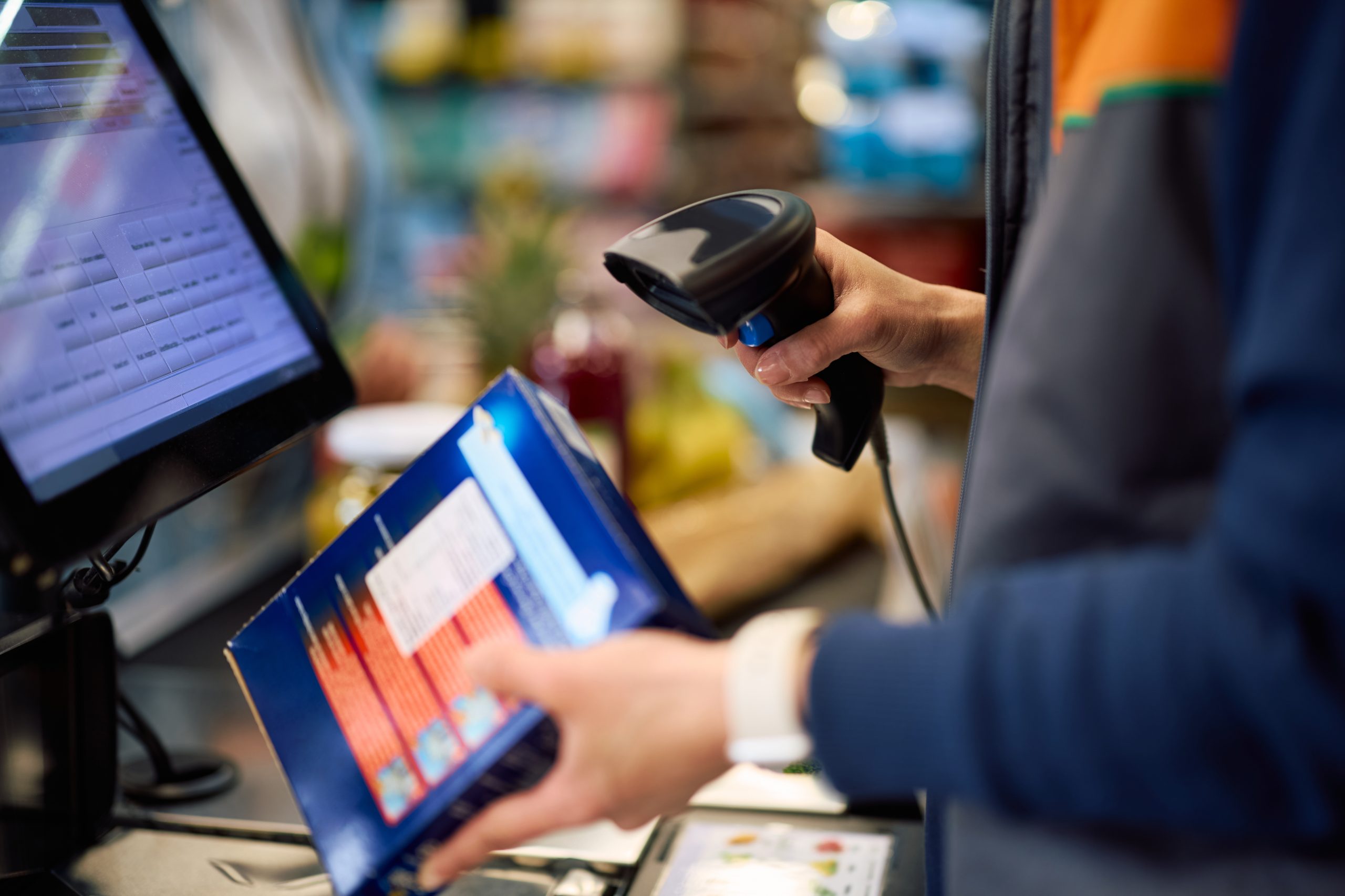 Close Up Of Cashier Scanning Products At Cash Register In A Supermarket. Close Up Of Cashier Scanning Products At Cash Register In A Supermarket.