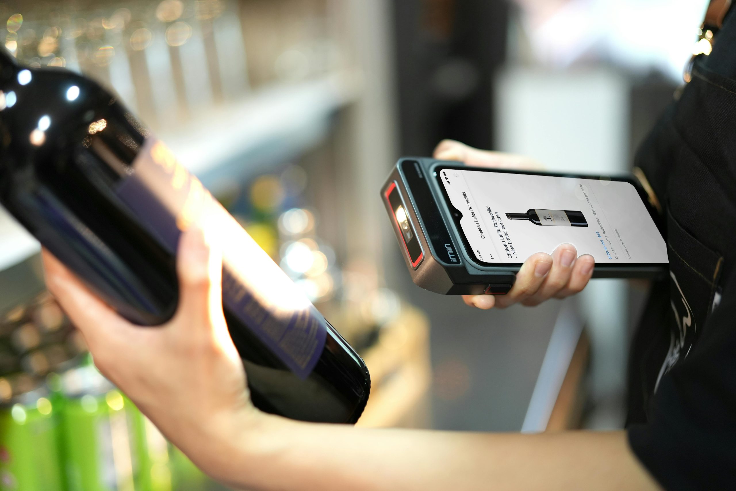Retail Staff Scanning a Wine Bottle with a Handheld Barcode Scanner Device