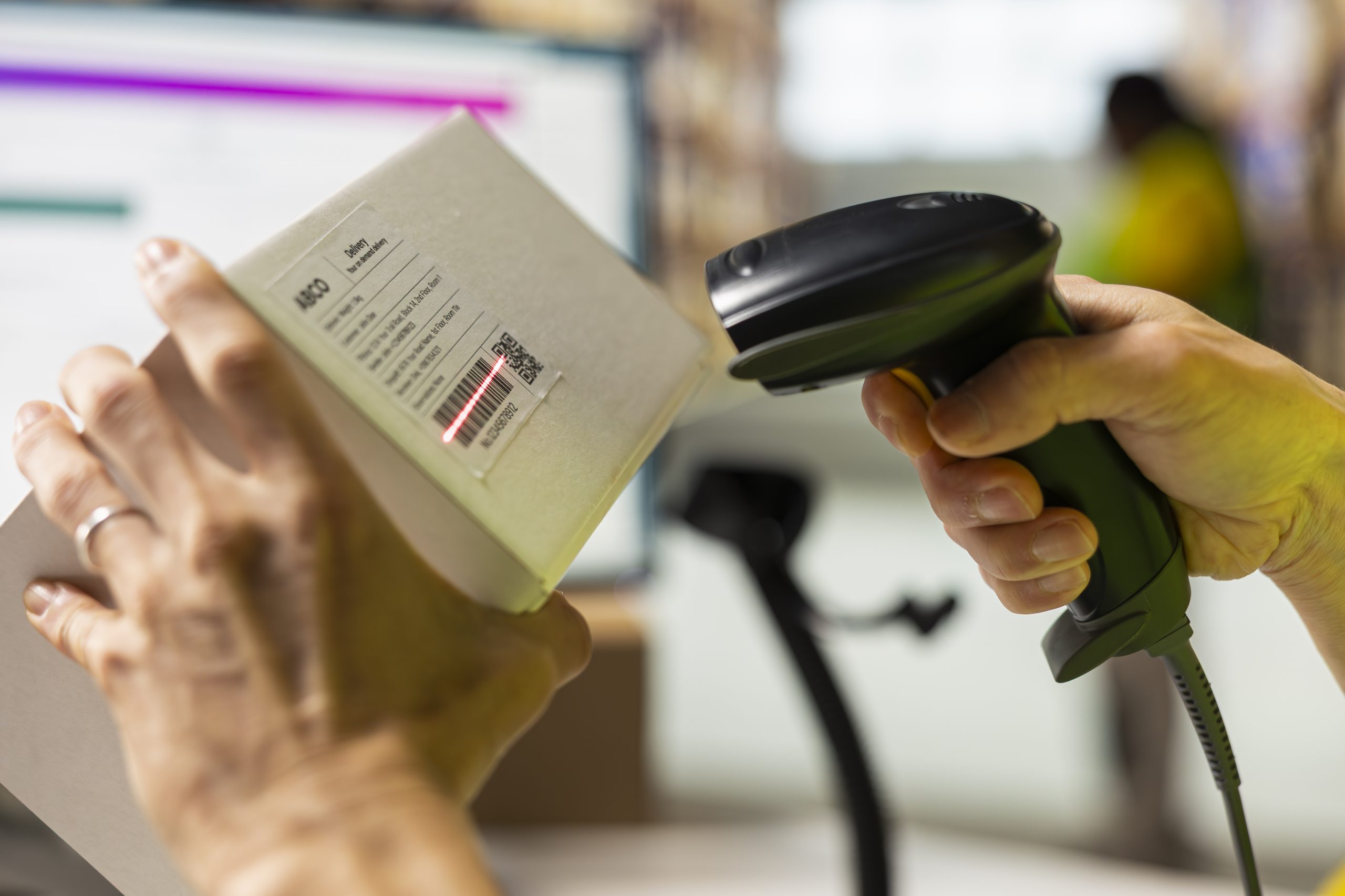 Close up of worker manages cargo barcode scanning in a distribution hub, preparing the goods with packaging, tagging and inventory checking. Man using a scanner in fulfillment center.
