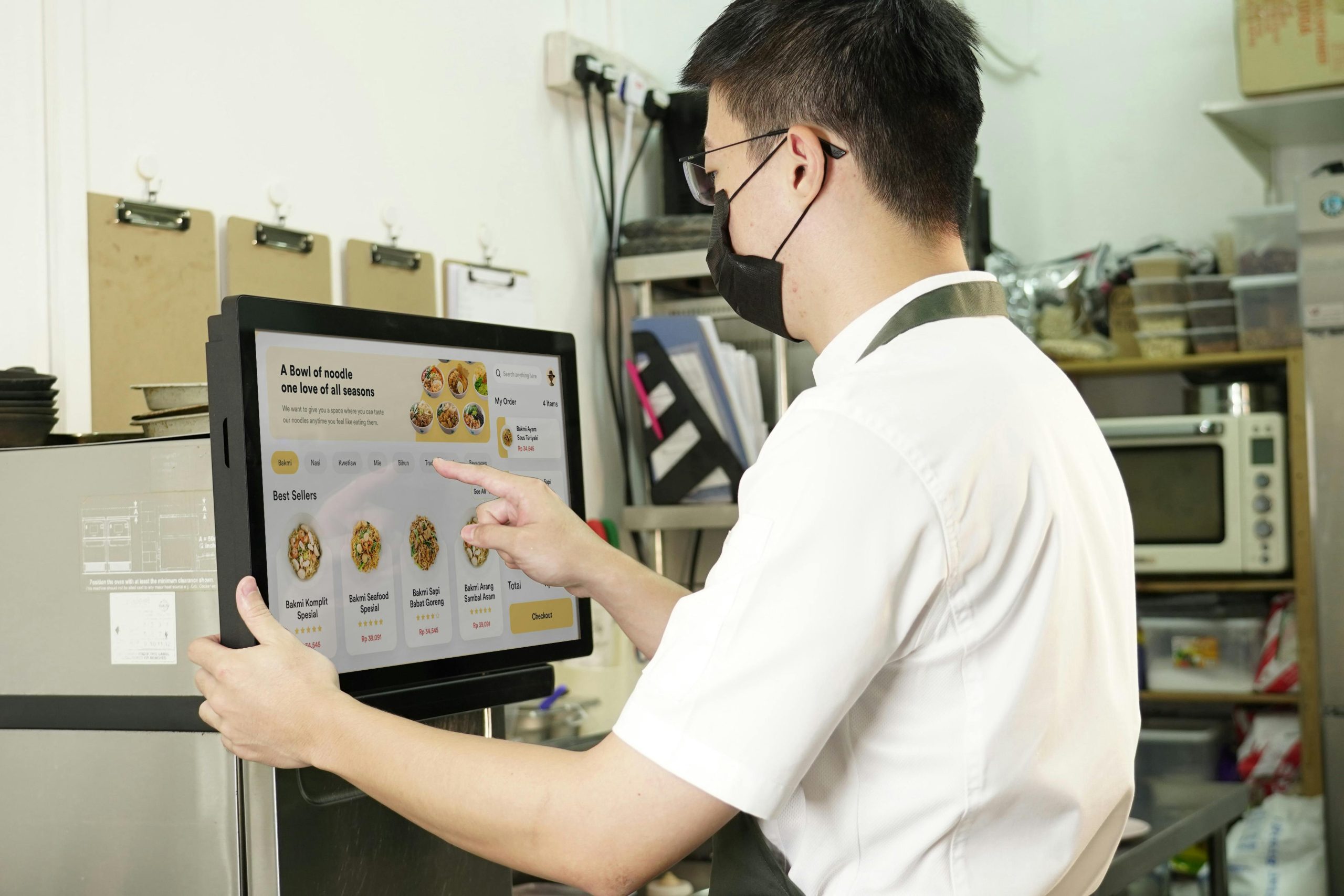 A Restaurant Staff Member Interacting with a Digital Menu on a Touch Screen POS Monitor A Restaurant Staff Member Interacting with a Digital Menu on a Touch Screen POS Monitor