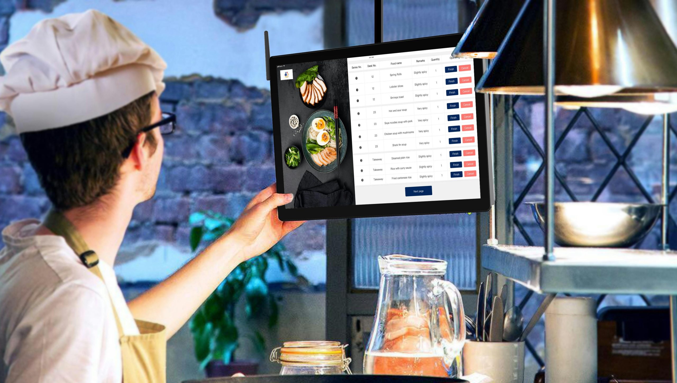 A Chef Using a Mounted Touch Screen Monitor to View Digital Orders in a Restaurant Kitchen A Chef Using a Mounted Touch Screen Monitor to View Digital Orders in a Restaurant Kitchen